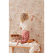 Majvillan Dollhouse Wallpaper 147-03 child sitting on bench putting sticker on wall